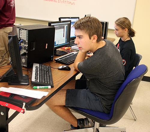 Sophomore Lucas Stewart and senior Hayley Morgan create firewalls to stop cyber attacks. The Cyberpatriot program prepares students for technology related careers. Photo by: Kaylin Kline