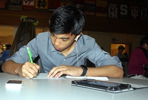 English Anguish: Sophomore Antonio Mendoza writes an essay on Lord of the Flies while referring to the digital book on his tablet.