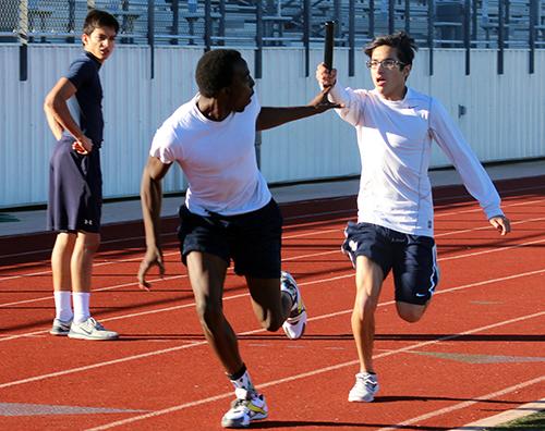 Sophomore De'Jaughn Padonu (left) and junior Phillip Sanchez-Torres pass the baton during a practice relay on Feb. 24.