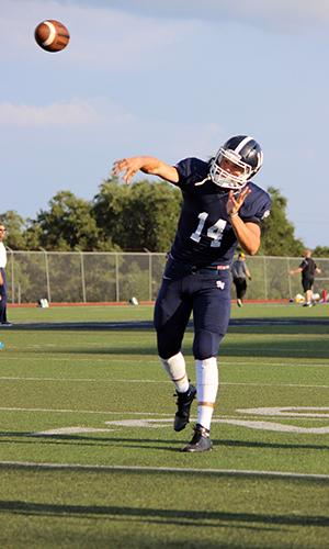 Quarterback Josh Adkins throws the football, practicing before the game against Brennan.