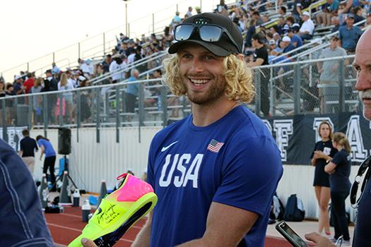 Alum Logan Cunningham holds his Team USA running shoes during the football game against Steele. The shoes and his jersey from Rio were donated to the school. 