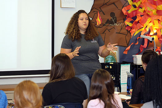 President Julia Kidd teaches in front of new members of the organization in room B103.