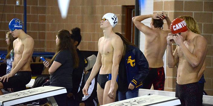 Sophomore Konnar Klinksiek stretches his arms behind the blocks before his events.