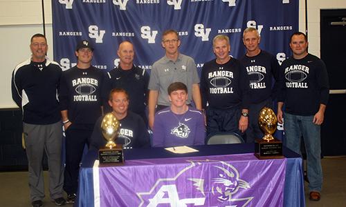 Senior Jack Gibbens, surrounded by his football coaches, signs his commitment to play at Abilene Christian University Feb. 6