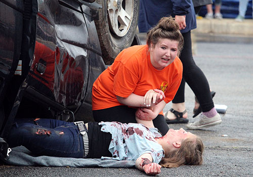 Portraying victims of a drunk driving crash, senior Emily Harrison cries over victim Hannah Pittman during Shattered Dreams. Accidents also can occur form distracted driving.  