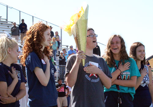 STAR athlete and torchbearer Zach Allen sings along to national anthem with cheerleaders and FACS volunteers on both sides.