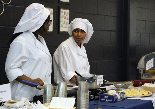 Autumn Estridge and Sydni Flowers discuss their dishes. Flowers served pigs in a blanket because it was an easy meal that someone would enjoy.