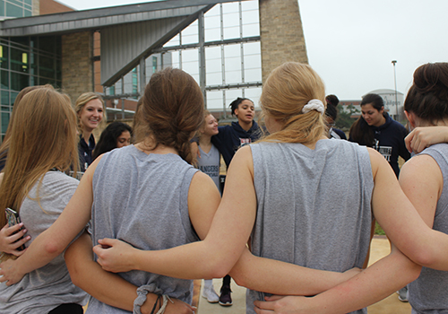 Attendees of see you at the poles break into groups singing together close in a circle.