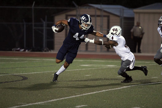 Senior Trevon Moehrig-Woodard stiff arms a Round Rock defender in the teams 50-10 victory over the Dragons on  Sept.  15 at Ranger Stadium.