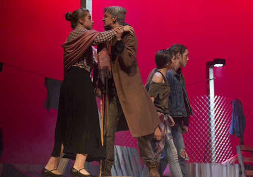 Olivia Pertruso as Lady Montague holds back Hunter Hyland as Lord Montague, while Kayla Cassidy and Katelyn Burgh as town persons watch a fight between the Montages and Capulets break out.