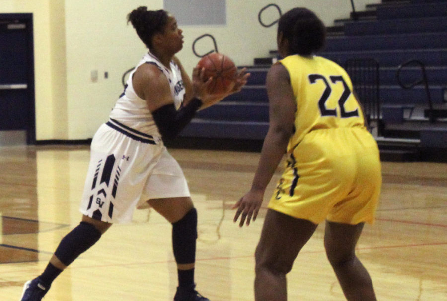 Senior Taylor Green gets the ball at the top of the key and looks to pass.