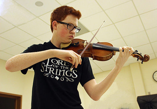 Anthony Couvillion plays his violin before school in the choir room. 