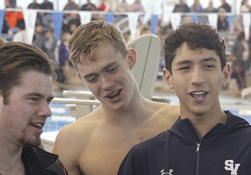 Junior Cale Farnsworth, junior Konnar Klinksiek, and senior Frankie Garibay lead the team in a cheer before the start of the meet Jan 6. 