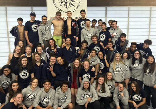 The aquatics team poses on the medal stand after their total team victory was announced. Both the women's and men's team took first place last Saturday.