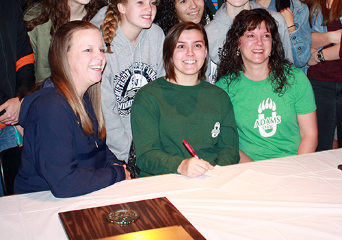 Avery Wilson sits in between Coach Kari Osborne  and her mother. She signed with Adams State University to swim. "I love the location," she said. "It has my major of environmental science too."