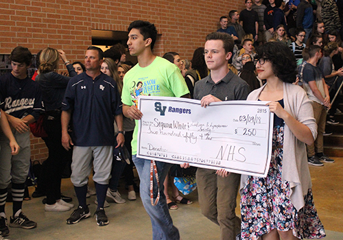 NHS officers Bobby Palomin, Joseph Miller and Maria Rocha carry their organization's check for $250.