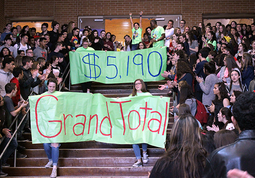 With FACS sponsor Tina Olcott celebrating at the top of the stair, FACS representative carry the banners announcing the grand total of $5,190 raised during SPUD Week. That exceeded the goal of $5,000. SPUD (Students Performing Unselfish Deeds) week included spirit nights at Spech't Store and Ay Chiwawa, Taco Tuesday with ROTC, a faculty-student basketball game and the annual dodgeball tournament, all to raise funds for cancer survivor Sequoia White and the Leukemia Lymphoma Society.