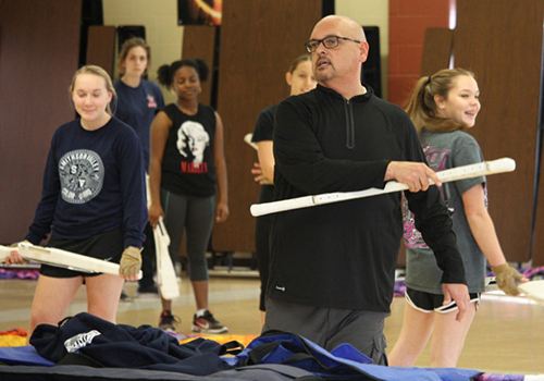 Assistant band director Sam Woodfeild directs the color guard.