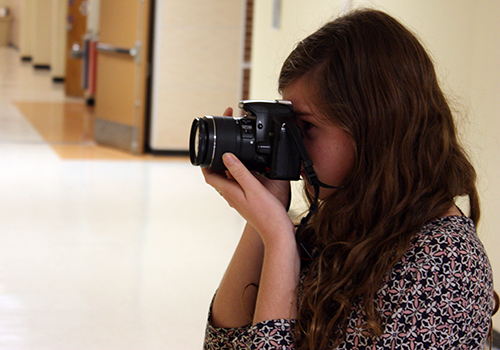 Senior Emma Sipple takes pictures for a prom story in A-wing on April 2.