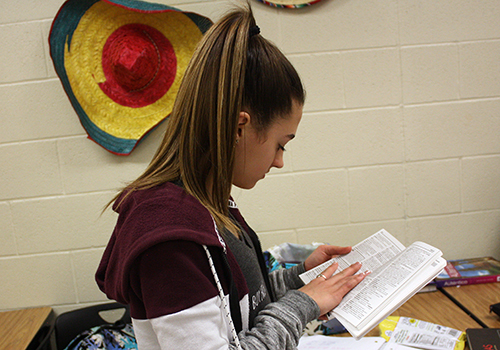 Freshman Zoey Madigan flips through a Spanish-to-English dictionary as she searches for the right word to fit in her Spanish project for Chris Helkey's Helkey’s seventh period class.  
