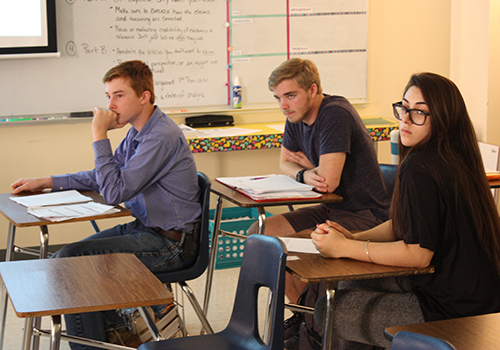 Juniors Sean Gunther, Cade Gibson and Kaley Bared look over a released AP Seminar test on May 7 to prepare for their test tomorrow.