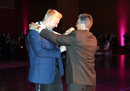 Senior Michael Smith gives a bright smile as he receives the Most Courteous superlative from principal Michael Whal at prom on May 12.