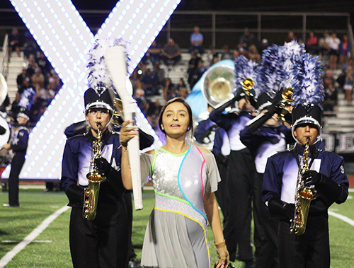 At the Steele football game, band members Alyssa Wagner, Adam Cevallos and Senior color guard member, Aliyah Wotenia perform their UIL show eXpiriment 78070. 