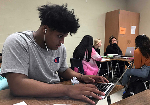 Senior Dylan Sinegal works on an assignment in Roseanne Gray's third  period English IV class.
