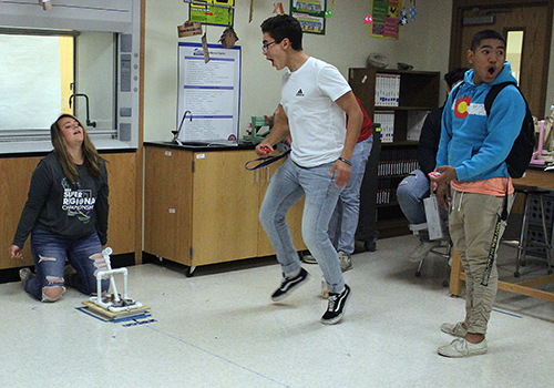 After hitting the target with a catapult they built, scientists Nicole Gomez, Joaquin Rodriguez and Gabe Altamirano in Christine Warzecha's physics class celebrate.