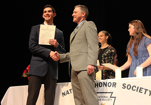 A newly inducted National Honor Society member, junior Carlo Garcia received his certificate and a congratulatory handshake from principal Michael Wahl on Nov. 30.