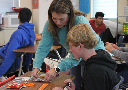 With Cheez-Its, scissor and pencil on hand, math teacher Claudia Soliz demonstrates how to use angles to create boxes.