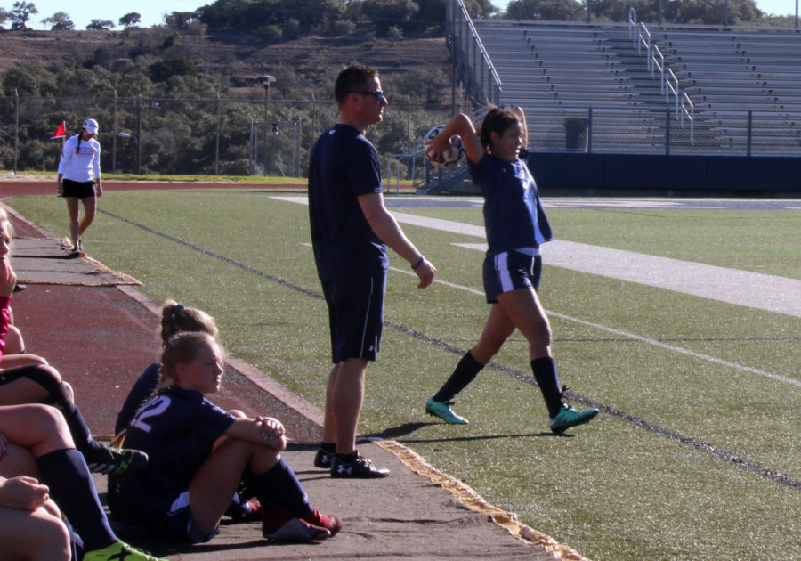 Senior defender Jasmine Odom throws the ball in as head coach Jason Adkins watches during their final game of the Ranger Classic on Jan. 5.