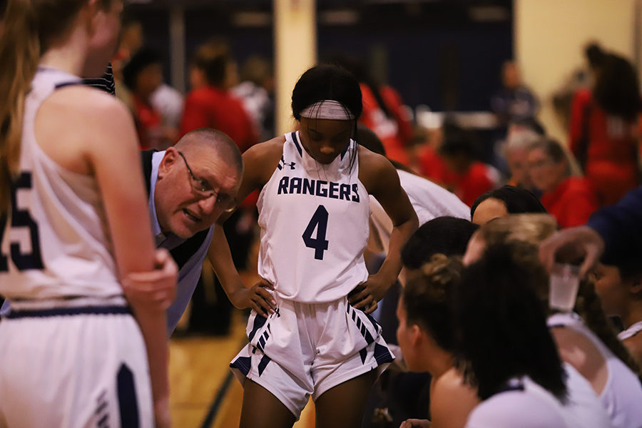 Huddled around Coach David Farber, girls basketball team members lean in for a strategy to beat Judson, 64-62, at the final buzzer.