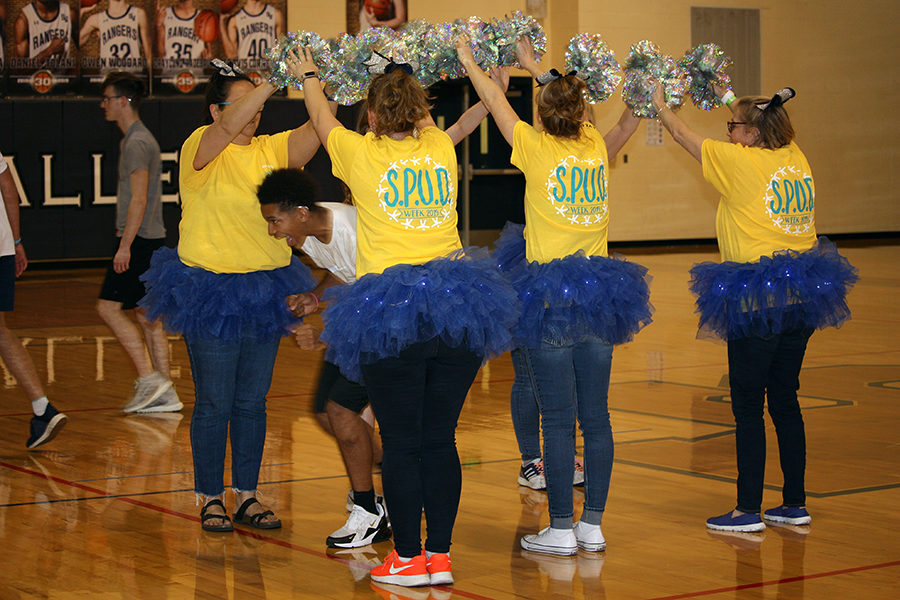 Cheering teachers raise their pompoms so Kylen Morton can run through.