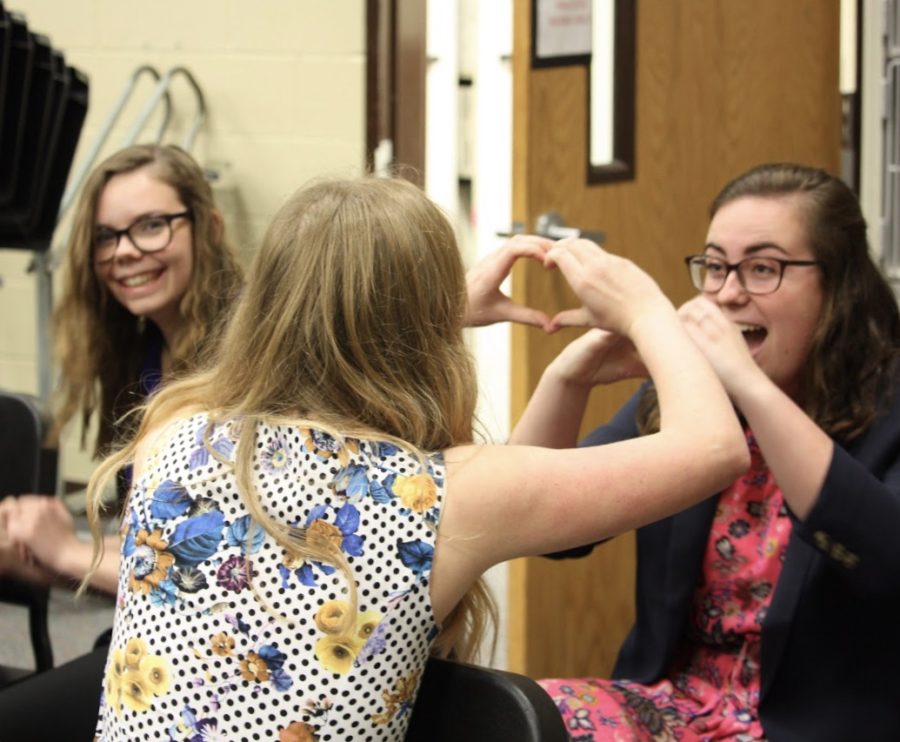 Juniors Caroline Kuhn and Rileigh Mccullough decompress prior to auditions while sophomore Maya McBrayer smiles on.