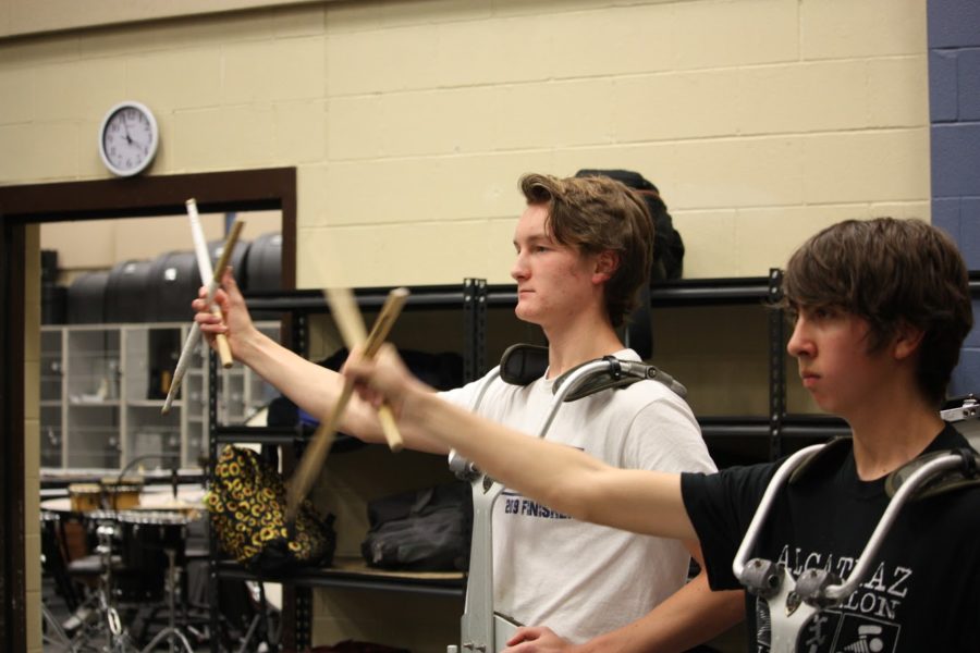 Junior percussionists William Yancosek and Mark Olaez swing their arms in time with the alma mater.