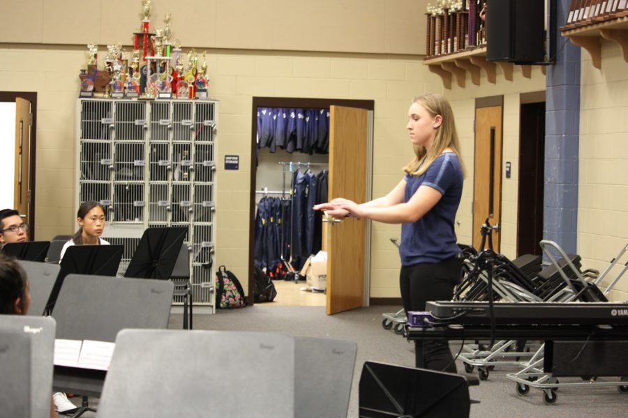 Sophomore french hornist Kaleigh Kirkpatrick readies herself for her showing while sophomore clarinetists Iris Bradbury and Jonathan Nunez view.