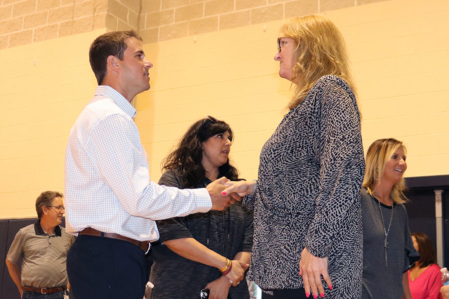 After being introduced by Coach Larry Hill, girls basketball coach Matthew Sutherland shakes hands with parent Michelle Grell.