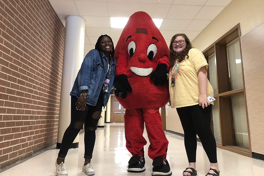 FACS members Alexia Harris and Lyndsey Reyes guide Derius Young around school to recruit donors for the Oct. 2 blood drive.