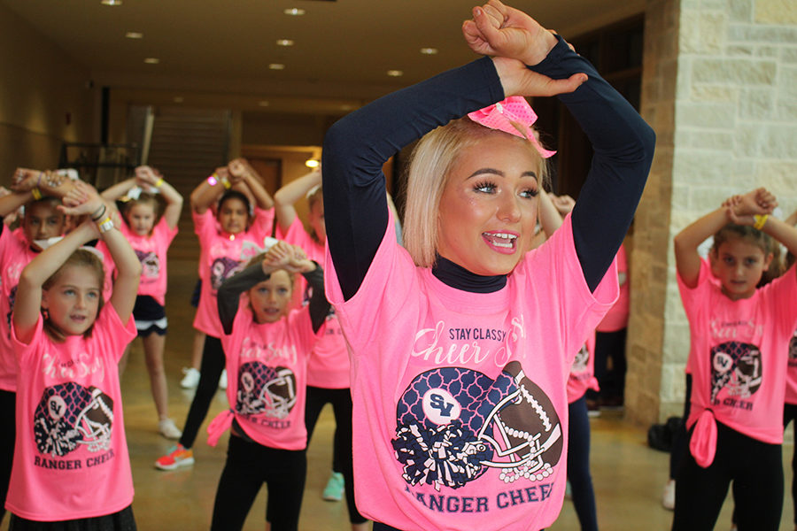 Demonstrating a cheer during the 2018 cheer clinic, senior Kamryn Moore leads a group of kindergartners through eigth graders. The 2019 clinic will take place Oct. 19 at the school.