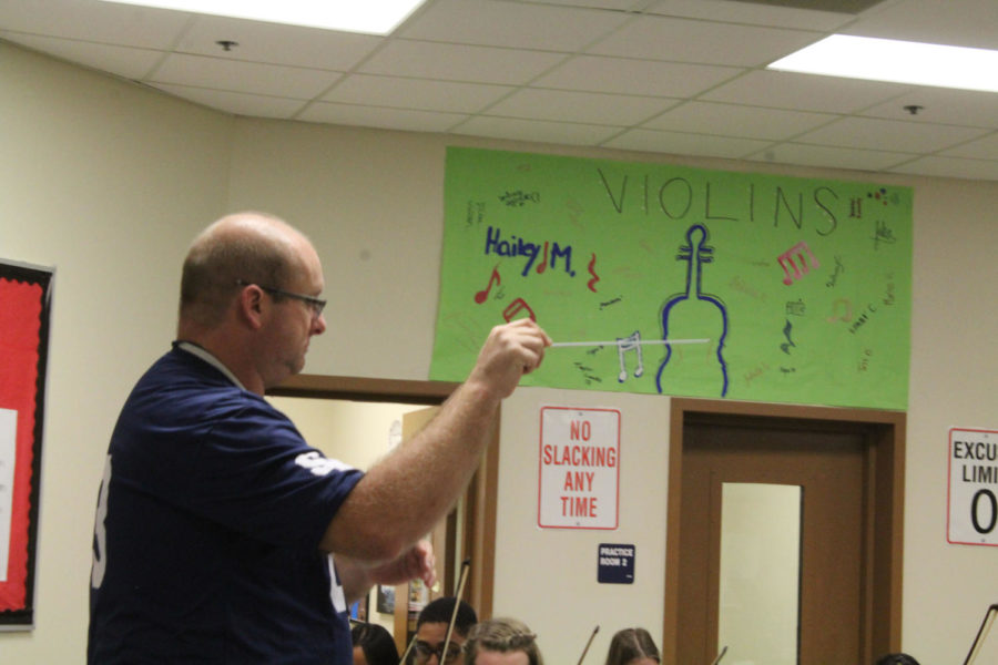 After second period orchestra gathers for rehearsal, Richard Helsley conducts his string players for the upcoming Mid Texas Symphony.