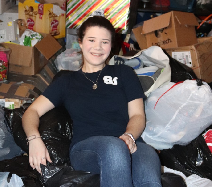 In the middle of a day's worth of gathering shoes, Redin lounges atop a heap of donated shoes. 