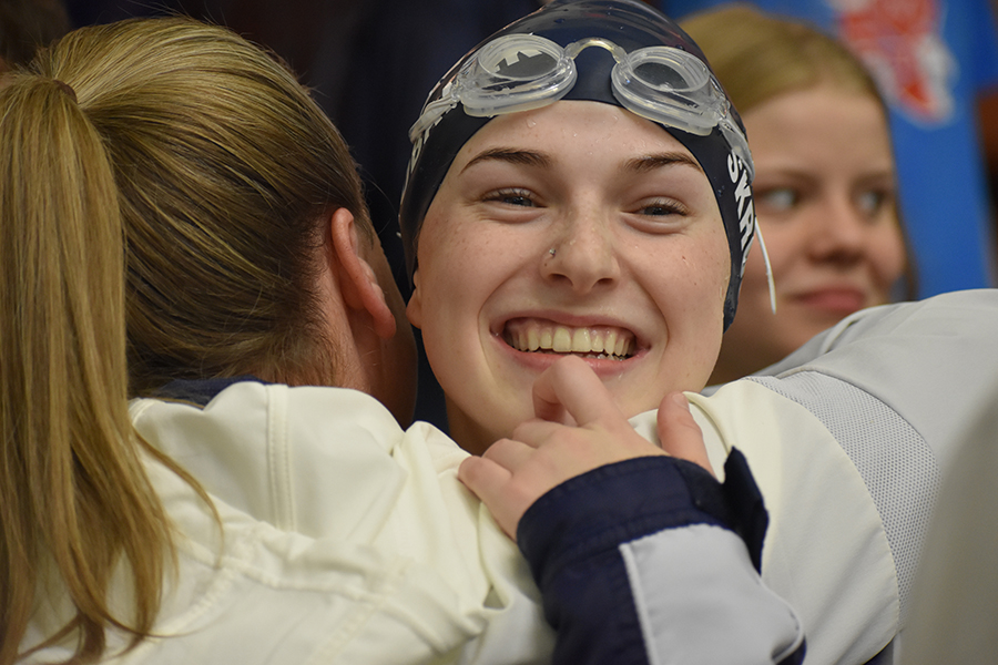 Hugging Coach Kari Osborne, sophomore Laney Skrobanek celebrates her gold medal finish in the 100 meter backstroke at the region meet Saturday at the Josh Davis Natatorium.