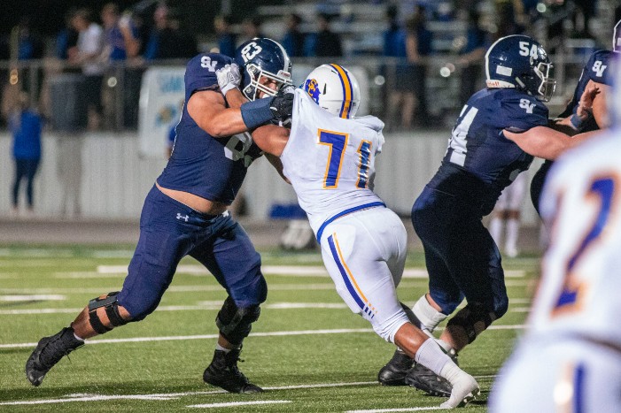 Ryan Benca lays a block on a defensive lineman. Benca and his teammates will kick off district play Friday at Wagner.