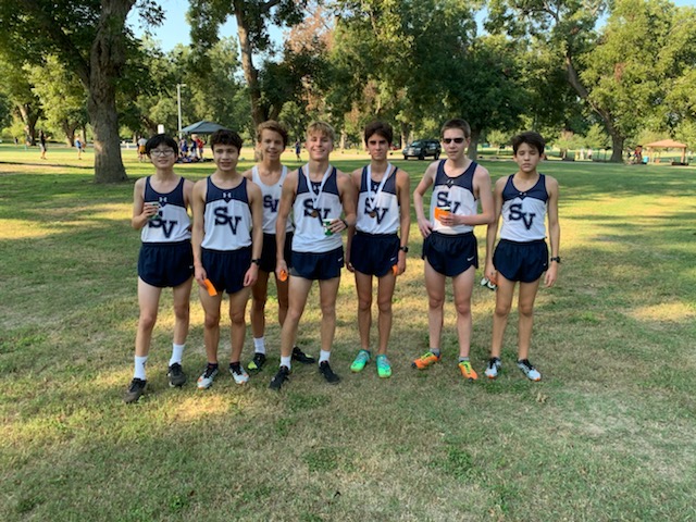 Junior varsity players stand holding their medals after a successful finish.