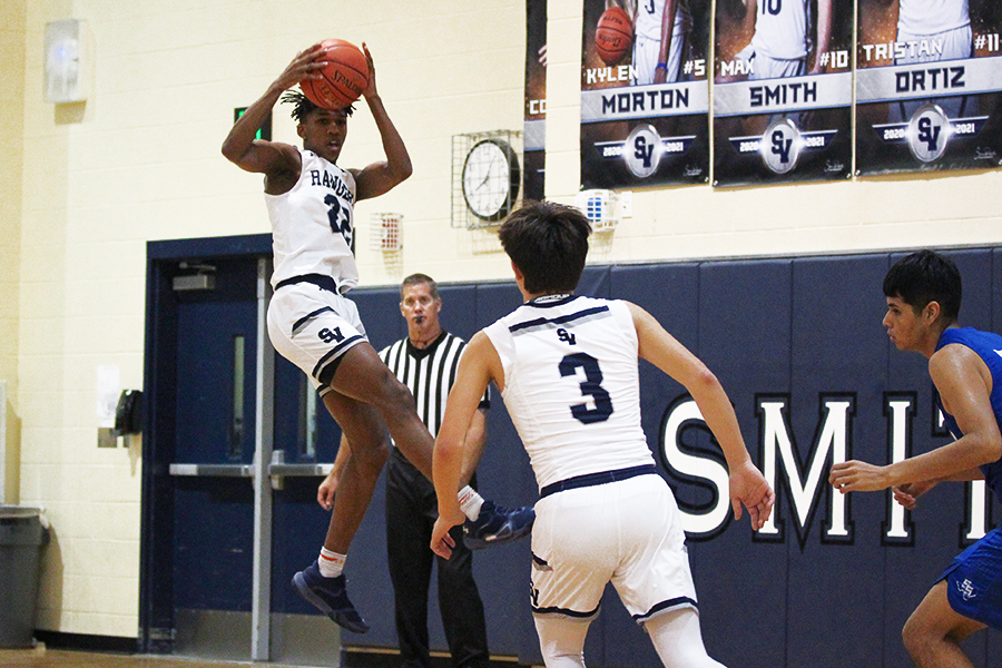 During district play Jan. 8 at home, junior Tevijon Williams pulls down a rebound against South San before senior Cody Garcia make his move down the court. Williams led all scorers with 14 points.