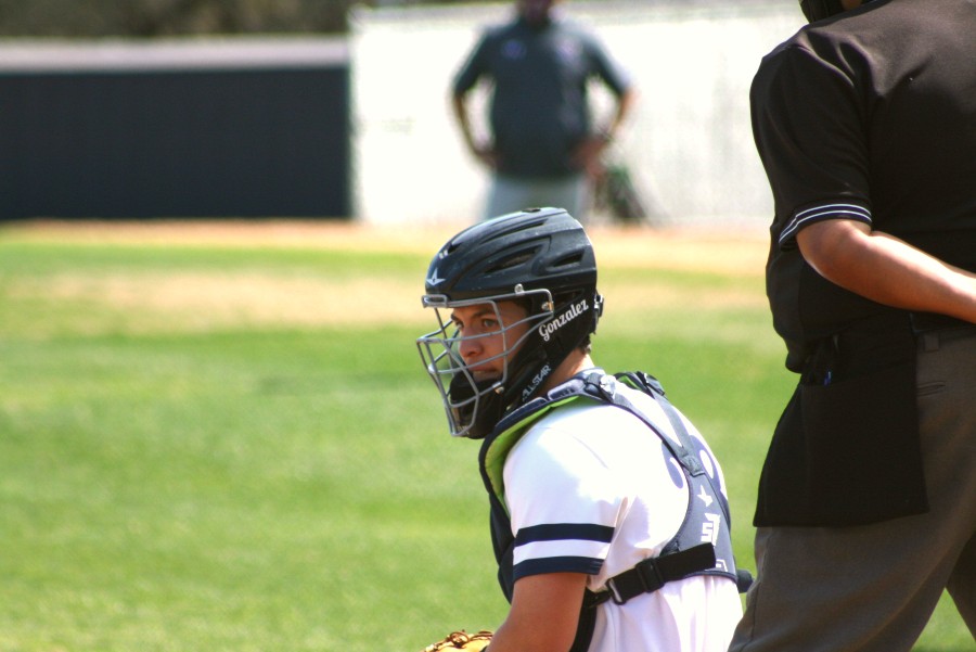 Crouching behind home plate, Ethan Gonzales peers towards the dugout. Gonzales, a sophomore, is committed to play at Texas Tech.