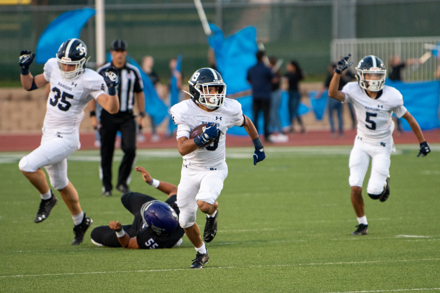Brayden Bafidis (center) charges past the Warren defense for a punt return touchdown against Warren on Aug. 27. That game saw the Rangers' first uniform change in two decades.