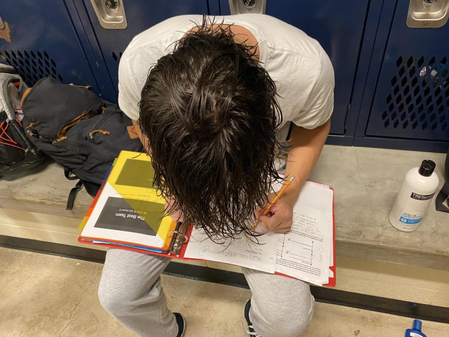 Junior Colin Doyle crams in studying in the locker room after swim practice.