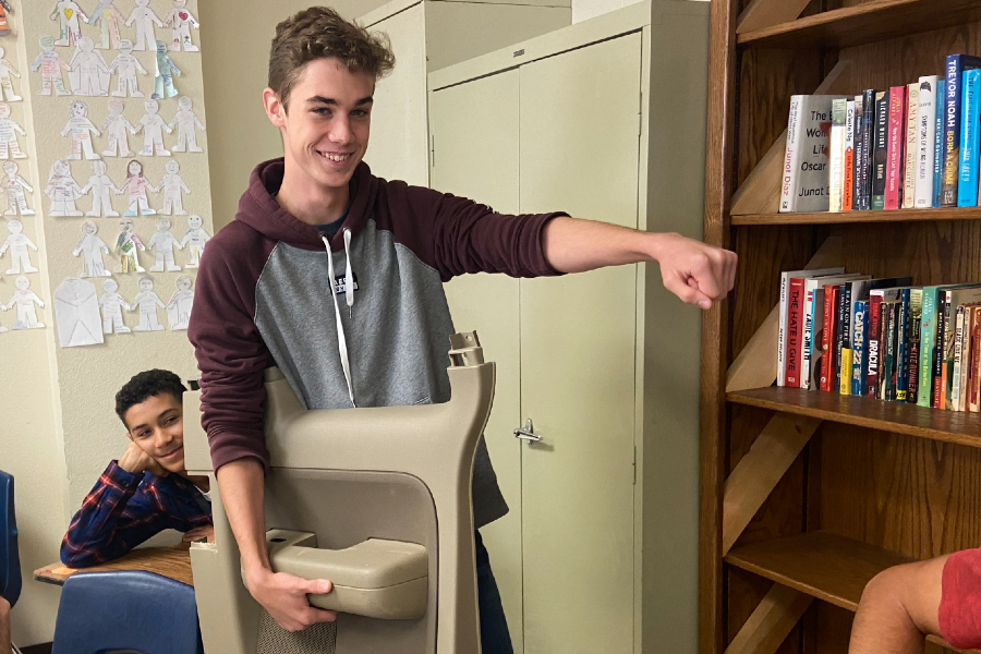 While brandishing a broken car door, senior Jacob Norman totes his school supplies in an unconventional way for Anything But a Backpack Day. He repurposed the door after it fell off his father's car. 